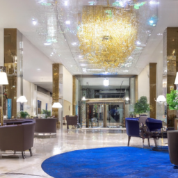 An image capturing the elegant lobby of DoubleTree by Hilton Hotel London - Marble Arch, featuring luxurious marble floors, a grand chandelier hanging from a high ceiling, and contemporary furnishings that exude sophistication and comfort