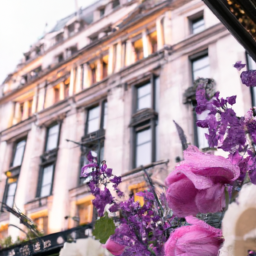 the timeless elegance of Radisson Blu Edwardian Bond Street Hotel in London through an image showcasing its grand façade, adorned with intricate Victorian-era architectural details and framed by vibrant blooms in full bloom